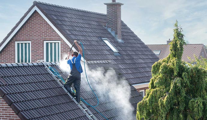 cleaner with power washing at roof house cleaning