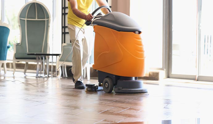 man is cleaning hotel lobby with industrial vacuum cleaner