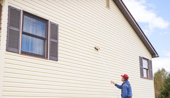 man washing vinyl siding