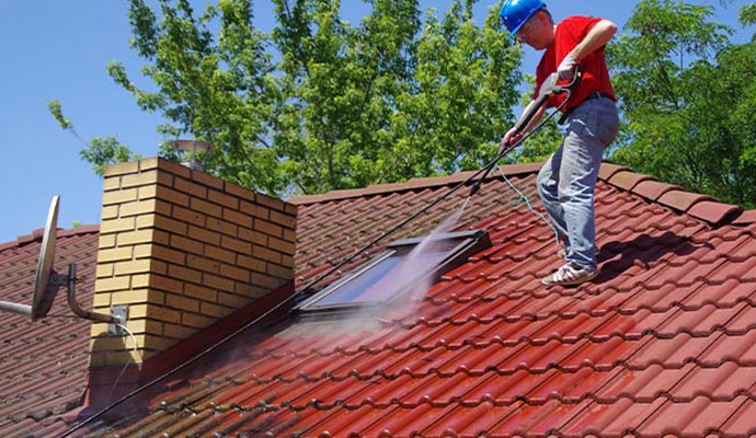 Worker seems to be power washing the roof in Holly Springs