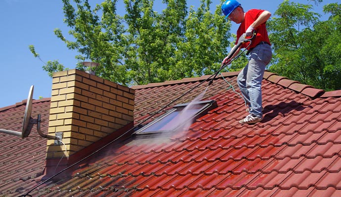 worker using with pressure tool house roof cleaning